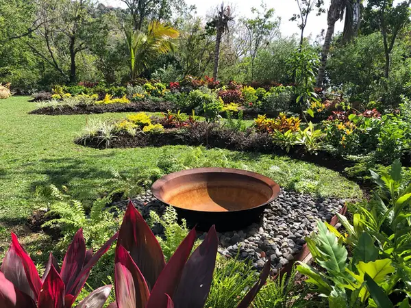 Stone birdbath surrounded by mixed garden planting
